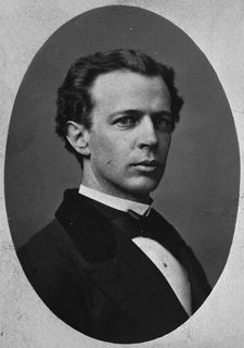 Photographie en noir et blanc de Wilfrid Laurier en habit, veston noir, chemise blanche et nœud papillon noir. Le corps et la tête de biais, il regarde directement de le photographe.